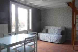 a living room with a couch and a table at Les Devants De Rupuanne in Bréhémont