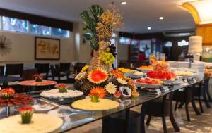 a long table with plates of food on it at Gran Lençóis Flat Residence in Barreirinhas