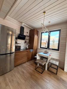 a kitchen with a refrigerator and a table with chairs at Drin-lux-cotteges in Slavske