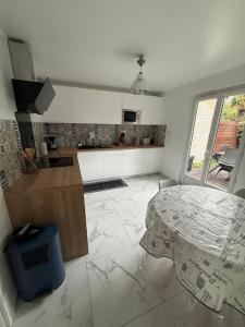 a kitchen with a table in the middle of a room at Demeure de charme paisible in Villepinte