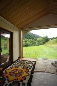 a bedroom with a large window looking out at a field at porichka in Korostov