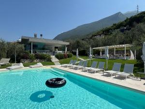 a swimming pool with chairs and a house at Guesthouse Grand View in Malcesine