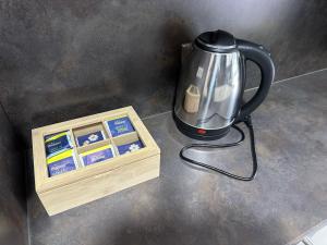 a tea kettle sitting next to a wooden box at Guest House BiBi-Lux in Ilsfeld