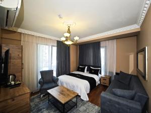 a bedroom with a bed and a couch and a table at İstanbul Royal Hotel Kumkapı in Istanbul
