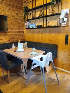 a table and chairs in a room with wooden walls at ChaleMani in Pill
