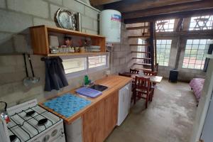 a kitchen with a sink and a stove top oven at Kima III in Huerta Grande +15 photos