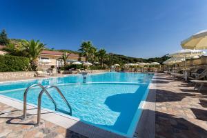 a swimming pool with chairs and umbrellas at a resort at Villa Santa Caterina in Montalto Uffugo