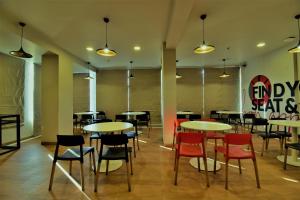 a dining room with tables and chairs and a sign at Hotel Manomay in Nagpur