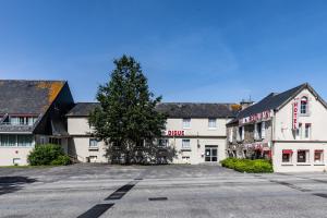 an empty street in front of two white buildings at Hotel De La Digue in Le Mont Saint Michel