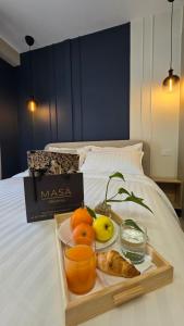 a tray of fruit and bread on a bed at MASA 2Rooms in Piazza Armerina