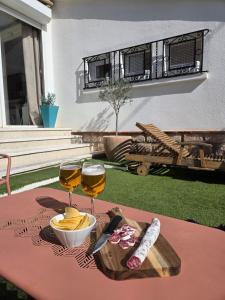 a table with two glasses of wine and a plate of food at Maison Valras Plage très bon emplacement in Valras-Plage +29 photos