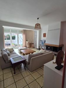 a living room with two couches and a table at Maison Valras Plage très bon emplacement in Valras-Plage