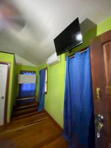 a room with blue curtains and a tv on the ceiling at 4J's Cabins in Santa Familia