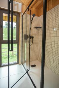 a bathroom with a shower with a glass door at porichka in Korostov +26 photos