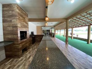 a large lobby with a stone wall and a fireplace at Suites Lara Jackson in Saquarema