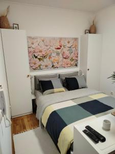 a bedroom with a bed with a painting on the wall at Studio SIESTA in Vrnjačka Banja