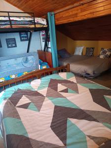 a bedroom with two bunk beds and a quilt at Chez Sylvia in Saint-Julien-du-Pinet