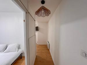 a bedroom with a white bed and a ceiling at Studio Neuf Centre - Chambre Séparée - Parking in Bressuire