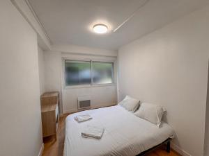 a small bedroom with a bed and a window at Studio Neuf Centre - Chambre Séparée - Parking in Bressuire +3 photos