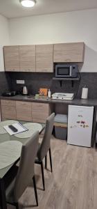 a kitchen with a table and chairs and a microwave at Andrea ubytovanie in Štúrovo