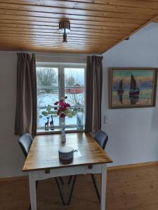 a dining room table with a vase of flowers on it at The Red Butterfly 2 cottage in Månstad