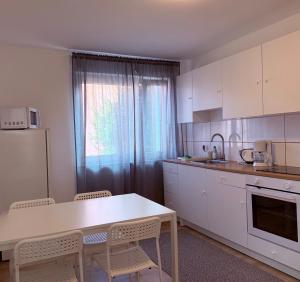a kitchen with white cabinets and a table and chairs at Ferienwohnung Oppenheim in Oppenheim +13 photos
