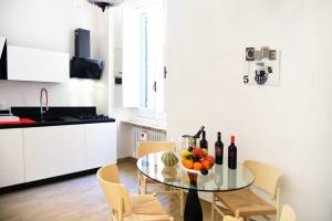 a kitchen with a glass table with fruits and wine bottles at La SignoraDelDuomo in Lecce +15 photos