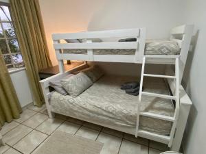 a white bunk bed with a couch in a room at Manasseh in Riversdale