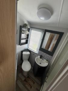 a small bathroom with a toilet and a sink at Trecco Bay Private rentals in Newton