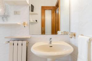 a white bathroom with a sink and a mirror at Trieste Sweet in Trieste