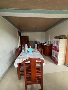 a kitchen with a table with chairs and a refrigerator at Taibessi in Dili