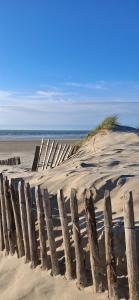 a wooden fence in the sand on a beach at Appartement coquet proche plage in Berck-sur-Mer +5 photos