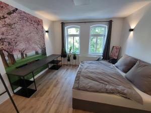 a bedroom with a bed and a desk and windows at City Residenz Jena - modern, groß, ruhig, zentral, 2 Balkone, 4 Zimmer, Küche, Bad in Jena