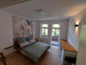a bedroom with a bed and a desk and two windows at City Residenz Jena - modern, groß, ruhig, zentral, 2 Balkone, 4 Zimmer, Küche, Bad in Jena +10 photos