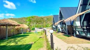a man walking in a yard next to a house at บ้านไม้หอมชาเล่ต์ in Suan Phung