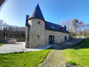 a large stone building with a black roof at Gîte Les Douets in Isigny-le-Buat