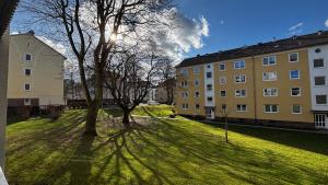 a tree in a grassy field next to a building at ask rooms Privatzimmer in Kassel in Kassel
