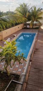 a large swimming pool next to a wooden deck at Residence Poolside Haven in Grande Gaube
