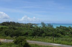 a road in a field with the ocean in the background at Residence Poolside Haven in Grande Gaube
