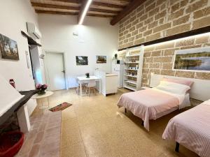 a bedroom with two beds and a brick wall at Masseria La Torre in Maglie
