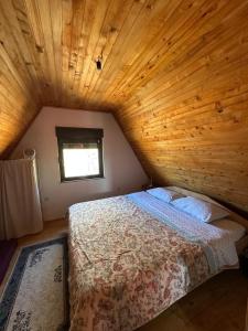 a bedroom with a bed in a wooden ceiling at Kuća za odmor VITICA s vanjskim kaminom in Kupres