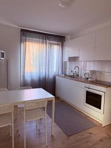 a kitchen with white cabinets and a table and chairs at Ferienwohnung Oppenheim in Oppenheim