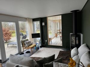 a living room with a couch and a fireplace at Cabin in the forest with Spa and Sauna in Västra Torup