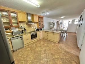 a large kitchen with wooden cabinets and appliances at Sand And Sea Self Catering #3 in Swakopmund