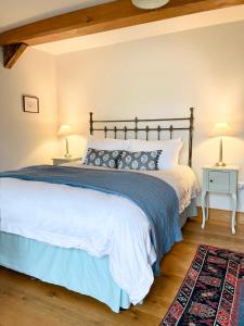 a bedroom with a large bed and two lamps at Mountain View Farm Cottage in Crickhowell