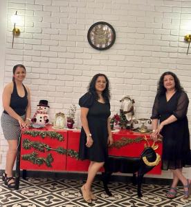 three women standing in front of a christmas table at Big Pvt Pool & Garden 3BHK Villa, Morjim Beach 10-14mts in Siolim +95 photos