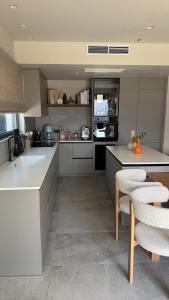 a kitchen with white cabinets and a counter and chairs at Villa Loggia in Ferendináta