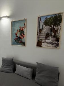 two pictures hanging on a wall above a couch at Apulian Dreams in Brindisi