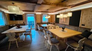 a restaurant with wooden tables and chairs and windows at Hecherhof in Viehhofen