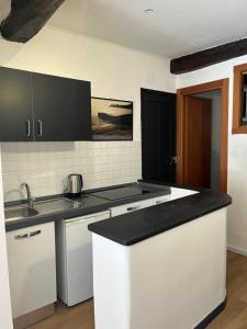 a kitchen with white cabinets and a black counter top at Santo 41 in Vernazza